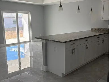 Kitchen island and open dining area with sliding glass doors